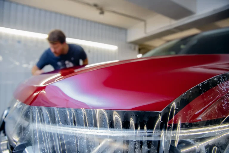 Close-up of car care professional installing paint protection film (PPF) with precision - Future of Paint Protection Film