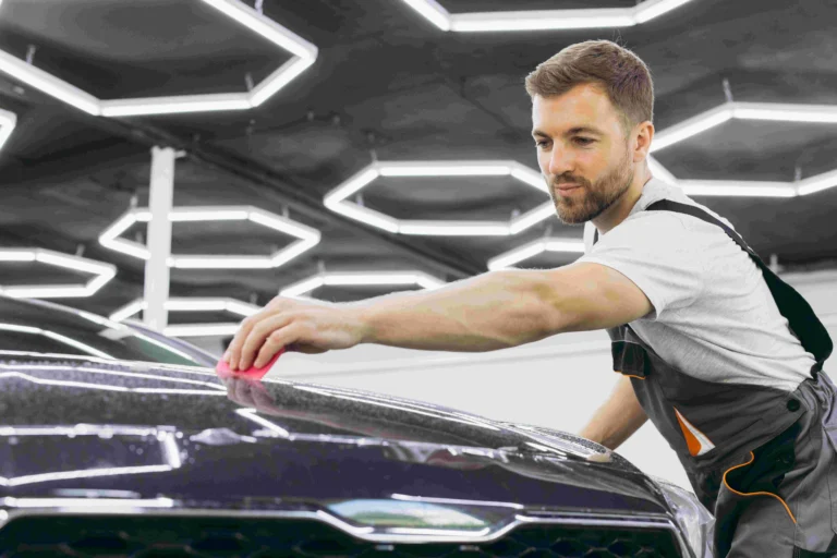 Car care installer, installing a ppf on a car in a detailing shop