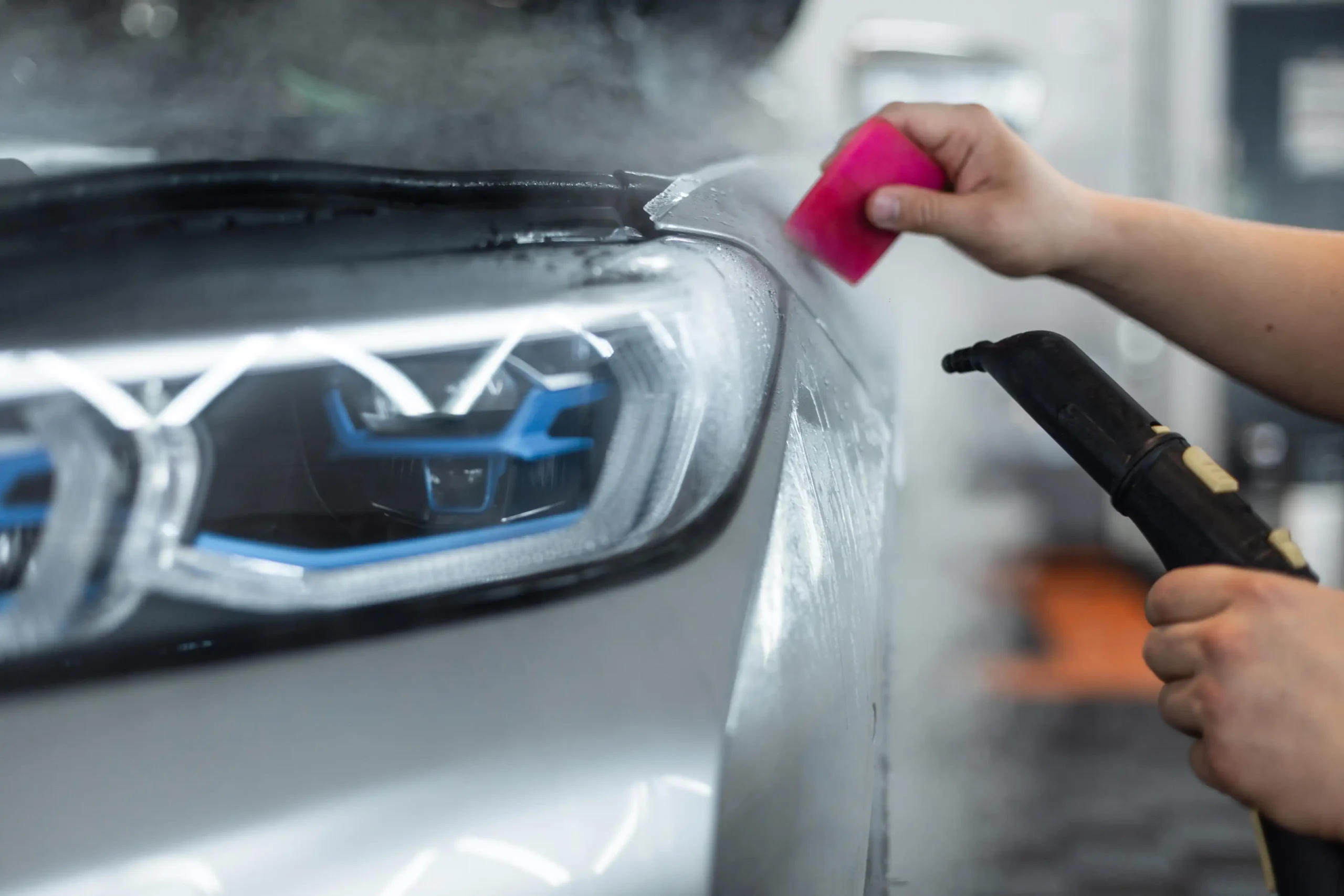 professional-man-covers-car-with-Luminous-protective-film-ppf-uses-steam-tool-detailing-service-care-care-winter-discount