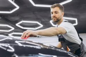 A car wrapping specialist applies a polyurethane film to the car. Selective focus. PPF protective film against chips and scratches. Car wrapping. black friday car care